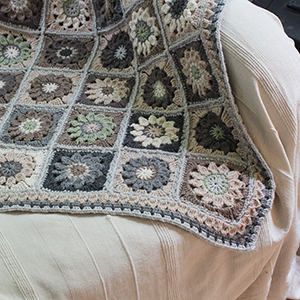 photo d'une couverture au crochet - granny squares assemblés 
				dans les tons beige et gris