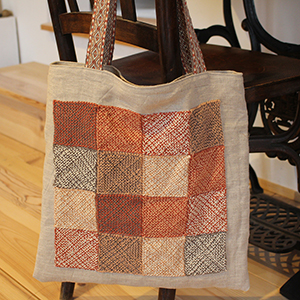 photo d'un sac en lin décoré de carrés tissés avec un pin loom - 
				anses tissées aux tablettes