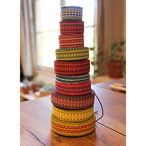 photo d'une pyramide de rouleaux de bandes
				tissées colorées
