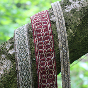 photo de trois galons en laine tissés aux tablettes
				dans les tons beige, brun, vert et rouge