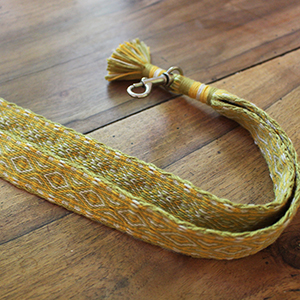 photo d'un porte-clés réalisé avec un 
				galon tissé aux tablettes dans les tons verts et jaunes